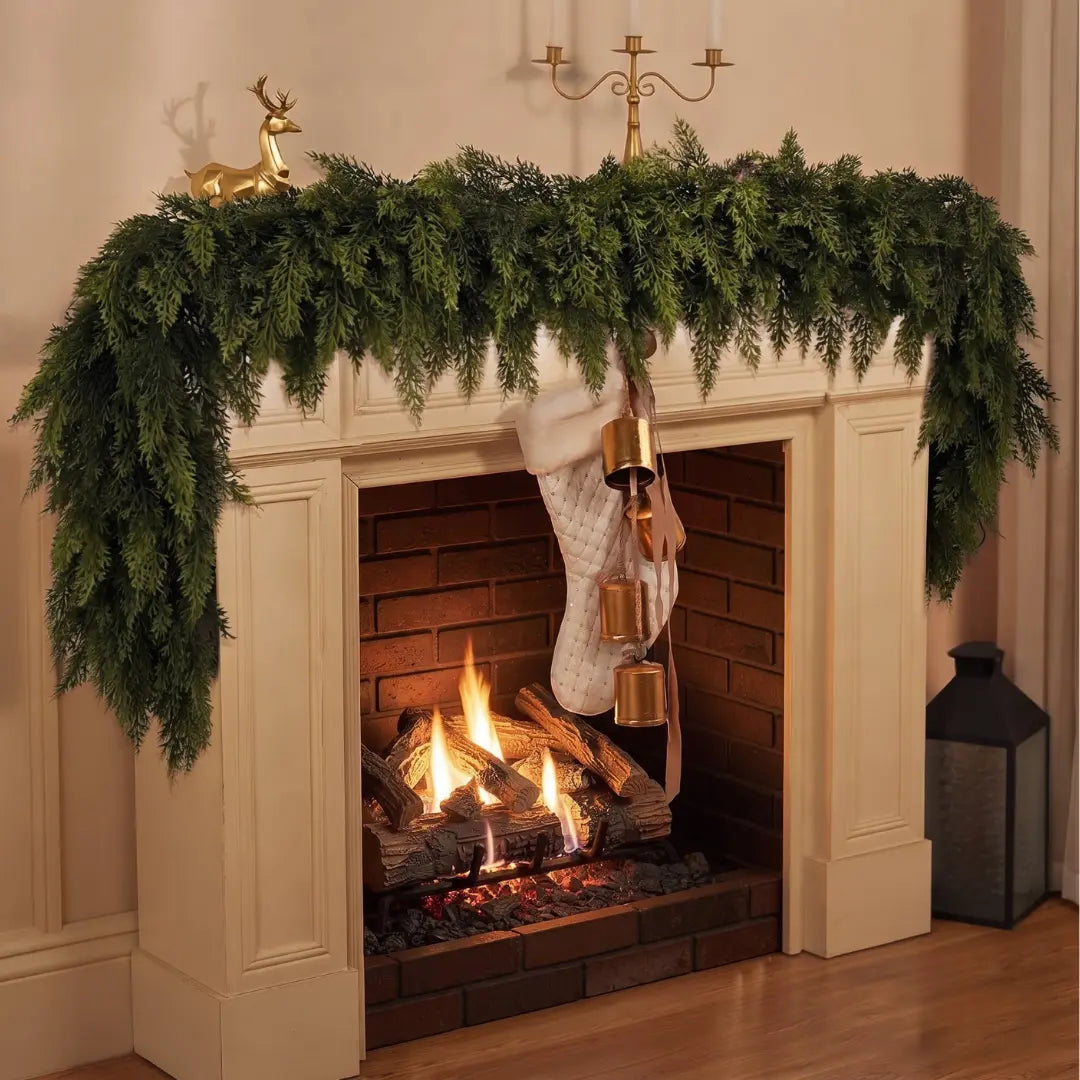Full cedar garland draped across a lit fireplace mantel with a stocking