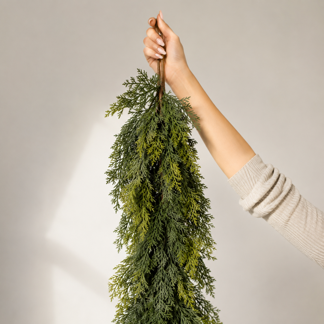 Hand holding a dense real-touch cedar garland strand